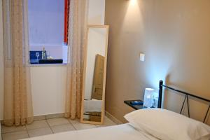 1 dormitorio con cama y espejo en Artemis No.2 Apartment, en Kissamos