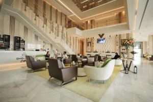 una hall di un hotel con persone sedute su sedie di VIP Hotel Doha Qatar a Doha Altre 34 foto