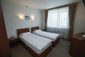 a hotel room with two beds and a window at Emerald Hotel in Yekaterinburg