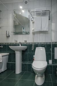 een badkamer met een toilet, een wastafel en een spiegel bij Emerald Hotel in Jekaterinaburg