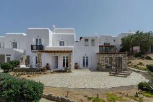 ein großes weißes Gebäude mit einer Bank davor in der Unterkunft Nefes Residence 2 bedroom villa in Agios Ioannis Mykonos