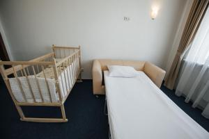 a hospital room with a bed and a crib at Emerald Hotel in Yekaterinburg