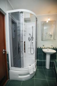 y baño con ducha y lavamanos. en Emerald Hotel, en Yekaterinburg