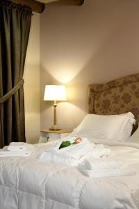 a bed with white sheets and a lamp next to a window at Aberratio Boutique Hotel in Aristi