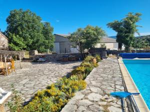patio trasero con piscina y patio de piedra en Gîte de Navacelles, en Blandas