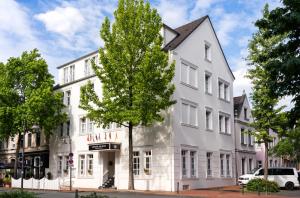 a white building with a tree in front of it at Arthotel ANA Fleur in Paderborn