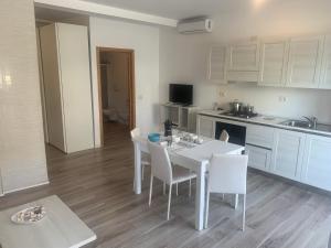 a kitchen with a white table and white chairs at Ca Marta in Sal Rei