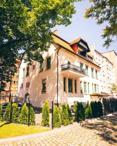 a large white house with a fence in front of it at Villa Art Novis in Wrocław