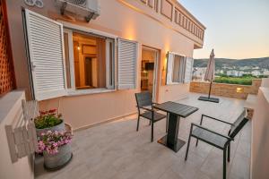 a patio with a table and chairs on a balcony at Artemis No.2 Apartment in Kissamos
