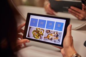 a person holding a tablet computer in their hands at Hotel Arsenaal Delft in Delft