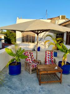 a patio with two chairs and a table and an umbrella at Balcony House in Zanzibar City