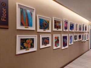 a wall with a bunch of paintings on a wall at CHRISTEE SUITES HOTEL in Melaka