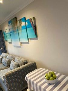 a living room with a couch and a bowl of fruit on a table at 35 on Bondi South Africa in Shelly Beach