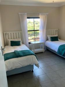 1 dormitorio con 2 camas y ventana en 35 on Bondi South Africa, en Shelly Beach