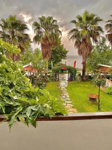 a garden with palm trees and a stone pathway at Peri Boutique Hotel in Sapanca