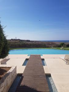 una piscina con passerella in legno accanto di THE LIGHTHOUSE a Paphos