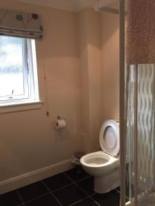 a bathroom with a toilet and a window at BCC Loch Ness Hostel in Bearnock