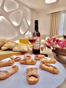 una mesa con una botella de vino y un plato de galletas en Hotel Boutique Suite Generis, Premiado El hotel más acogedor de España, en Córdoba
