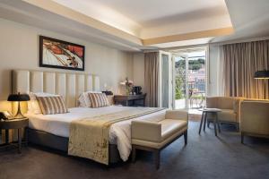 um quarto de hotel com uma cama grande e uma varanda em Hotel do Chiado em Lisboa