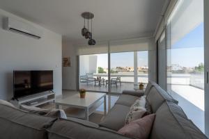 ラルナカにあるHarmonia 2-BR Apt in Livadiaのソファとテーブルのあるリビングルーム