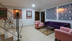 a living room with a purple couch and pink chairs at URLA PERA HOTEL in Urla