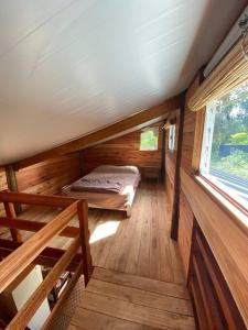 Habitación pequeña con cama en una casa de madera en Cabaña La Lechiguana, en Maldonado