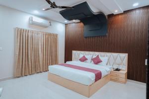 a bedroom with a large bed and a wall at Bajaj's Karwan Inn in Jagdalpur