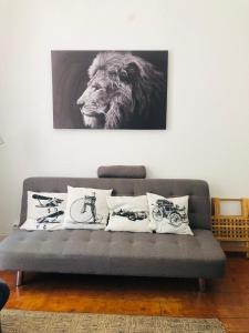 a couch with pillows and a picture of a lion at Casa do Mocho II in Lisbon