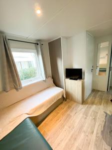 a small bedroom with a bed and a window at Charmant Mobil-Home 6 pers in Narbonne