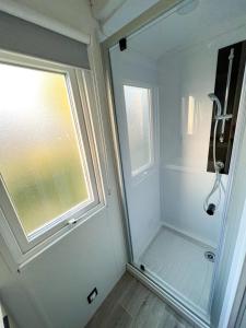 a bathroom with a shower and a window at Charmant Mobil-Home 6 pers in Narbonne