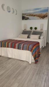 een slaapkamer met een bed met een kleurrijke deken erop bij Apartamento “CALMA” in Tarifa