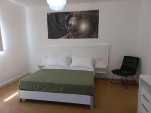 a bedroom with a bed and a black chair at HMO Glamping & Suites in Vignanotica in Mattinata
