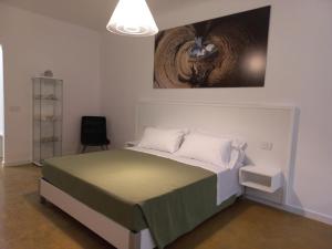 a bedroom with a bed and a chair and a painting at HMO Glamping & Suites in Vignanotica in Mattinata