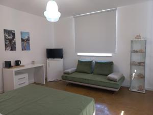 a living room with a green couch and a desk at HMO Glamping & Suites in Vignanotica in Mattinata