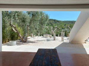 a wooden bench sitting on a patio with trees at HMO Glamping & Suites in Vignanotica in Mattinata