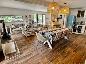 a living room with a table and chairs at Villa de charme avec piscine à 500m des plages in Soorts-Hossegor