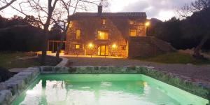 uma casa com piscina em frente a uma casa em Casa en paraje natural único 25 pax em Girona