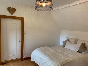 ein Schlafzimmer mit einem Bett und einer Decke in der Unterkunft Le Cocon de la Mare in Les Granges