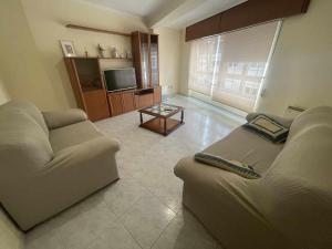 salon z dwiema kanapami i telewizorem w obiekcie Grupo Gontad Apartamento Cordobés, Ponteceso w mieście A Coruña