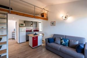 sala de estar con sofá y cocina en Ambroggio - Vue Mer, en Lumio