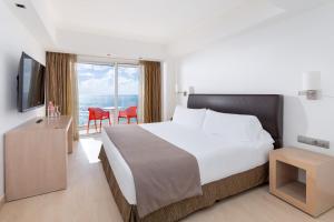 a hotel room with a bed and a television and a table at Hotel Cristina by Tigotan Las Palmas - Adults Only in Las Palmas de Gran Canaria