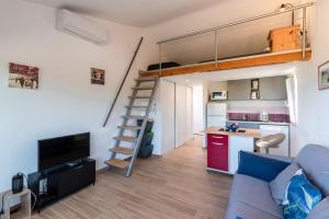 un soggiorno con divano e letto a soppalco di Ambroggio - Grand studio avec mezzanine - Vue Mer a Lumio Altre 6 foto