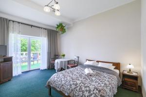 a hotel room with a bed and a balcony at Gościniec Zielony Domek in Mrągowo