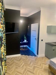 Pokój z czarnymi ścianami i niebieskimi drzwiami w obiekcie Apartamenty Green w mieście Stargard