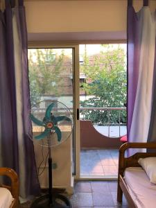 a room with a fan in front of a window at Sina Hostel in Tirana