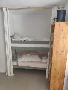 Pokój z 2 łóżkami piętrowymi i drewnianą szafką w obiekcie Petit coin de paradis en plein centre de Barèges w mieście Barèges