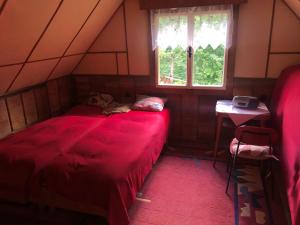 a dog laying on a red bed in a room at Chata Prístav in Námestovo