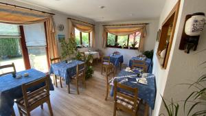 a dining room with blue tables and chairs at Hotel Pension Brilke Negast in Steinhagen