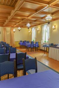a large room with blue tables and chairs at Heluan in Karlovy Vary