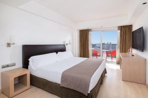 a hotel room with a large bed and a television at Hotel Cristina by Tigotan Las Palmas - Adults Only in Las Palmas de Gran Canaria